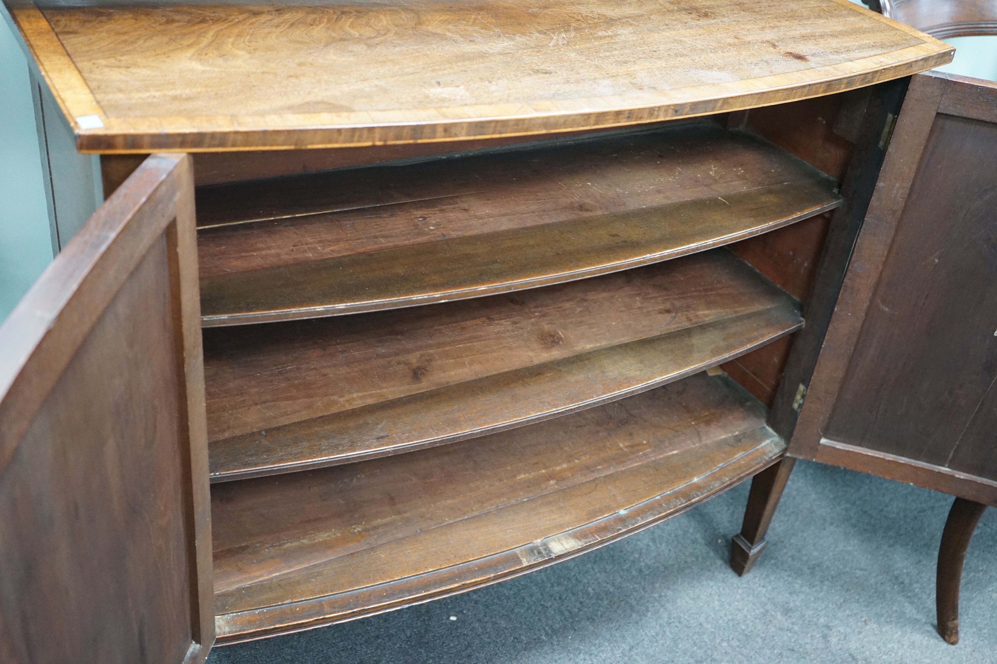 A George III mahogany and banded bowfront side cabinet with panelled doors on square tapering legs, width 103cm, depth 42cm, height 90cm